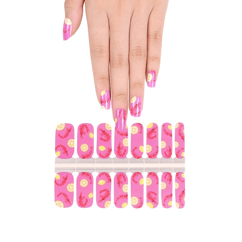 Hand above pink prawn nail wrap sheet showing at-home manicure application
