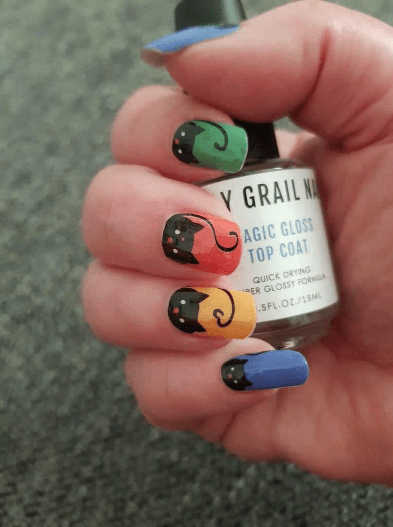 Non-UV nail wraps featuring adorable rainbow cat designs with top coat bottle for at-home manicure