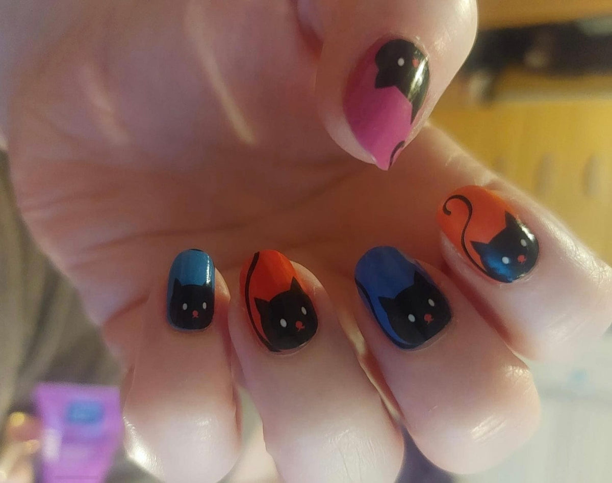 Cute cat nail art wraps in rainbow colours showing black cats on vibrant backgrounds