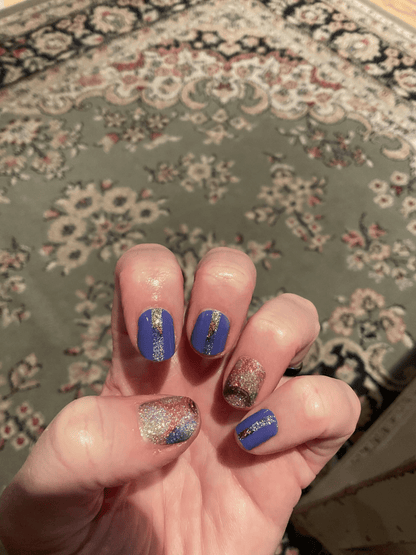 Blue glitter nail wraps with holographic rainbow accents on hand manicure