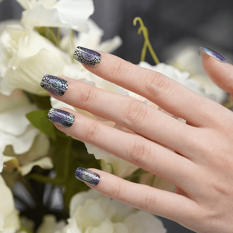 Holographic ombre nail wraps on hand featuring intricate black lace pattern manicure