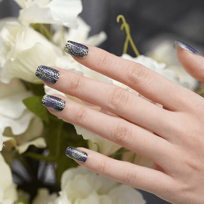 Holographic ombre nail wraps on hand featuring intricate black lace pattern manicure