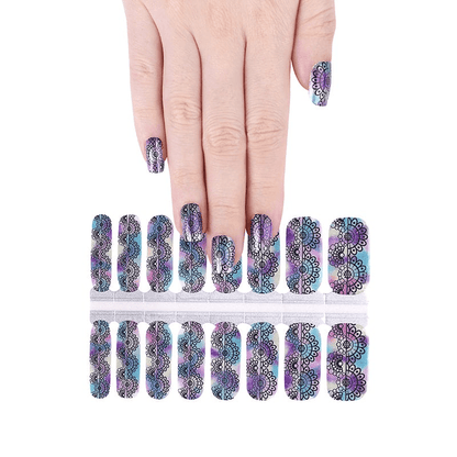 Hand displaying rainbow holographic ombre nail wraps with intricate lace pattern design