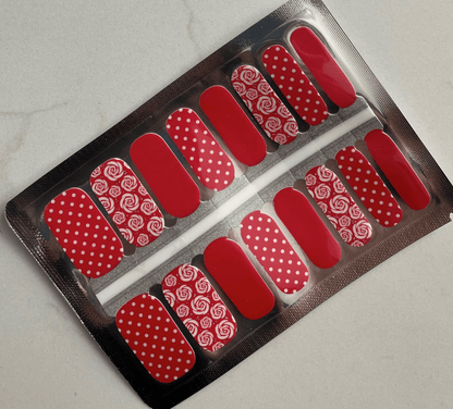 Red nail wraps sheet with white roses and polka dot patterns for at-home manicure