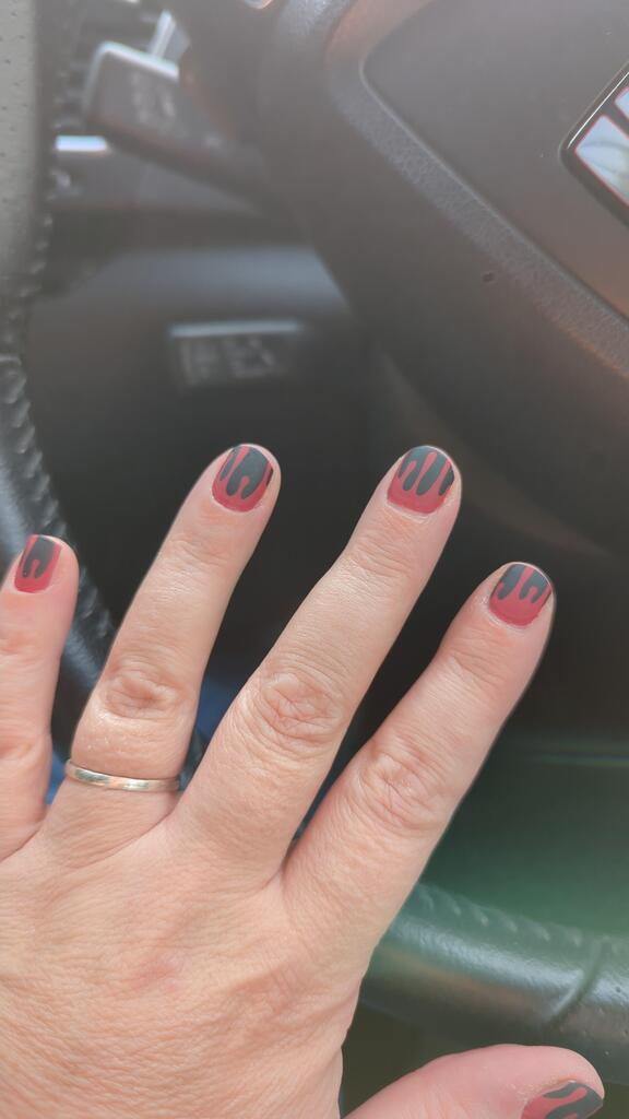 Red and black nail wraps with dripping drip-effect pattern on short round nails