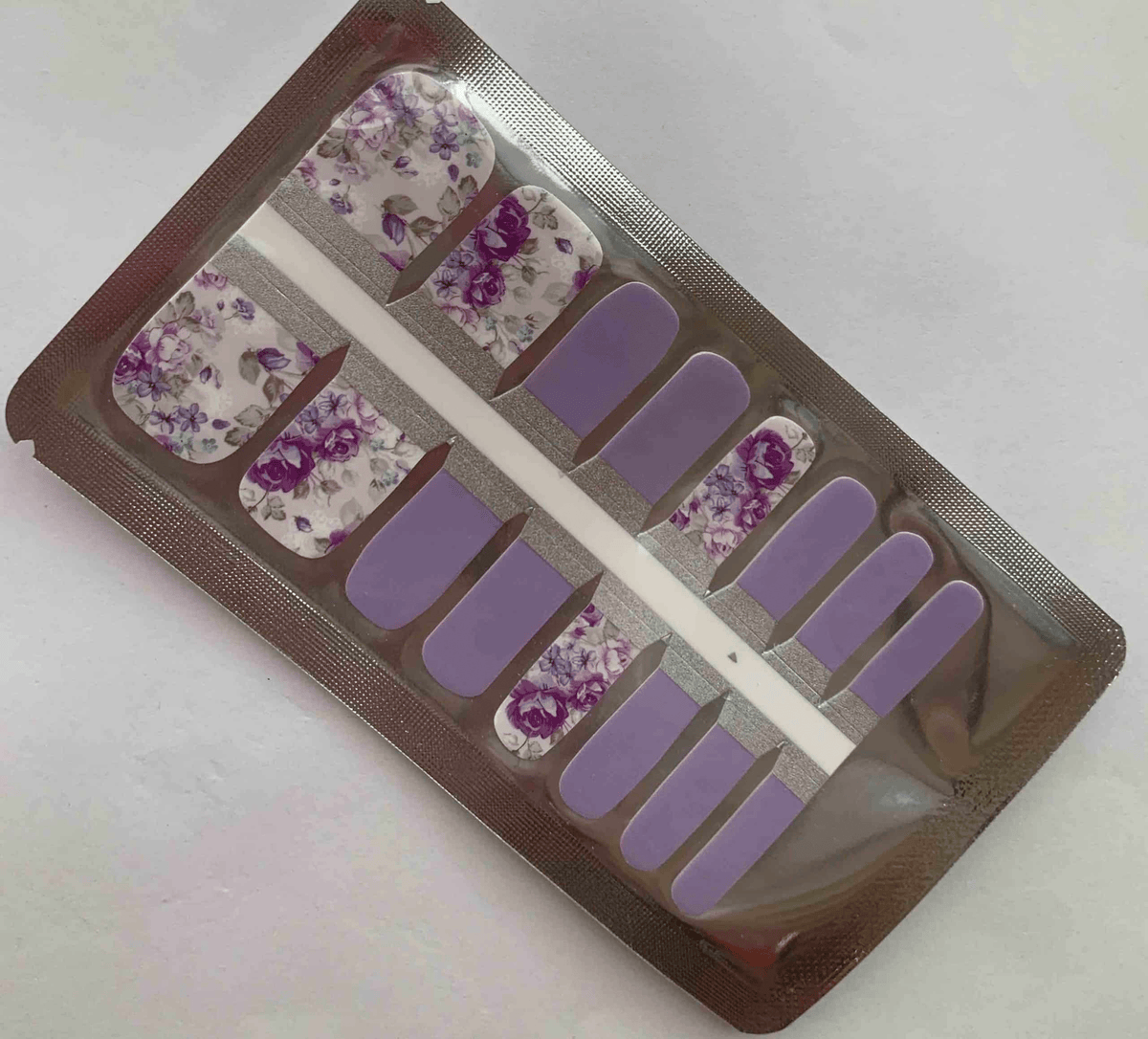 Purple lavender pedicure nail wraps with vintage rose floral patterns in packaging