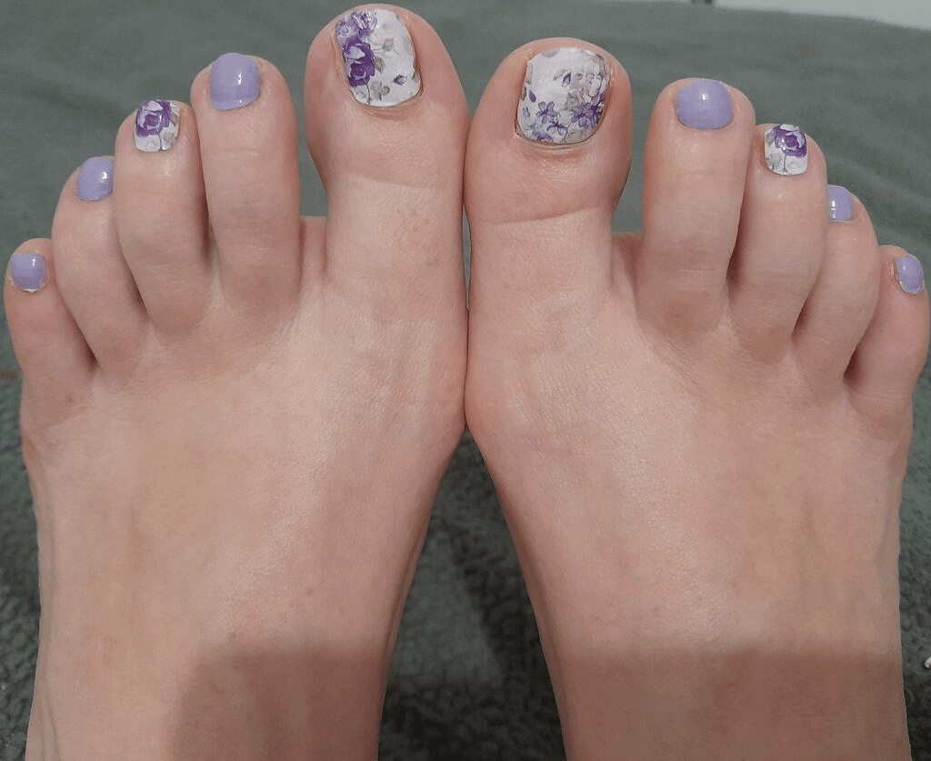Purple rose pedicure nail wraps applied to toes showing floral botanical design