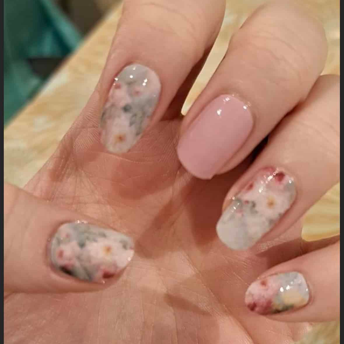 Glossy nail wraps with grey floral pattern and solid soft pink accent nail