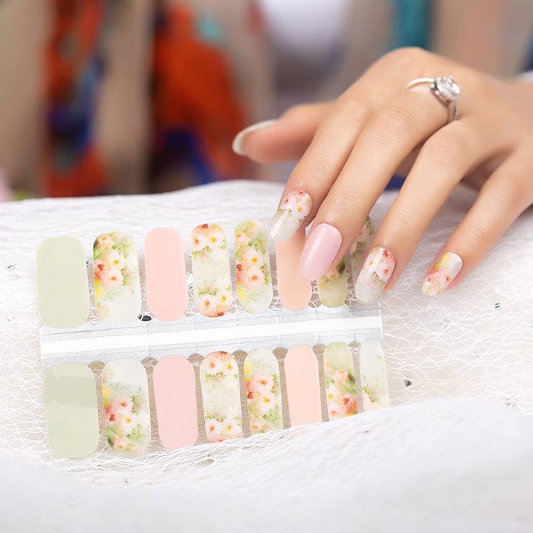 Hand applying pastel rose garden nail wraps with pink and floral watercolour design