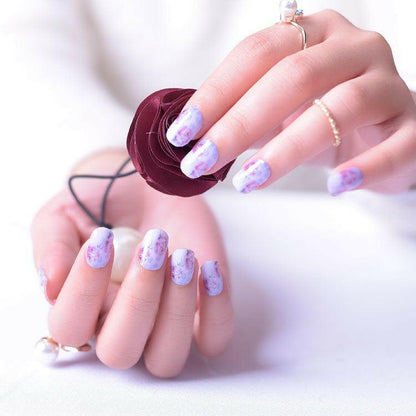 Pink and purple watercolour rose floral nail wraps on hands with circular UV lamp