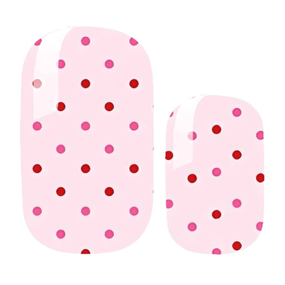 Pink polka dot nail wraps with red and pink spots on pale background