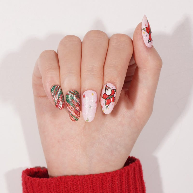 Christmas manicure nail wraps on hand showing Santa art, candy cane stripes and pink base designs