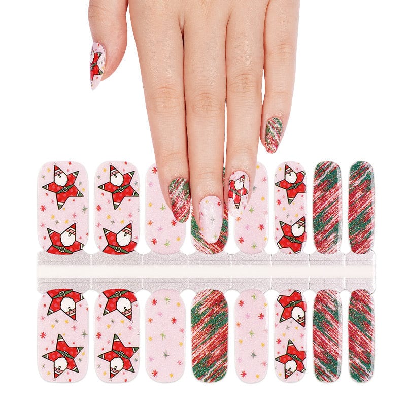 Hand applying Christmas nail wraps with Santa design and red green candy cane stripe patterns