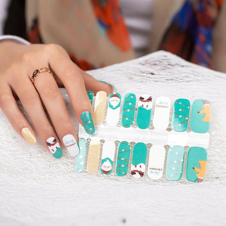 Hand wearing festive Christmas nail art wraps with Santa and gold glitter manicure designs