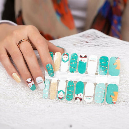 Hand wearing festive Christmas nail art wraps with Santa and gold glitter manicure designs