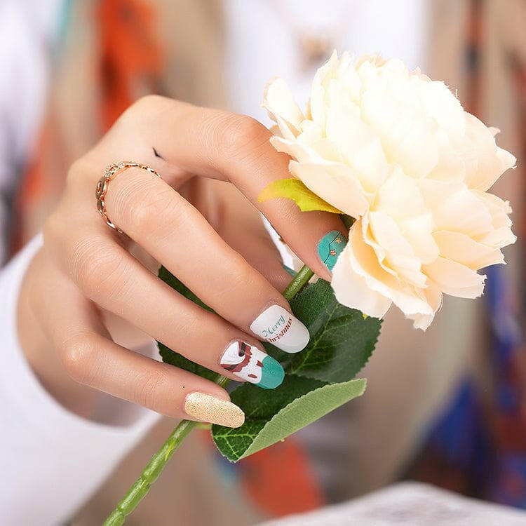 Hand holding white flower showing Christmas themed nail wraps with cute Santa designs