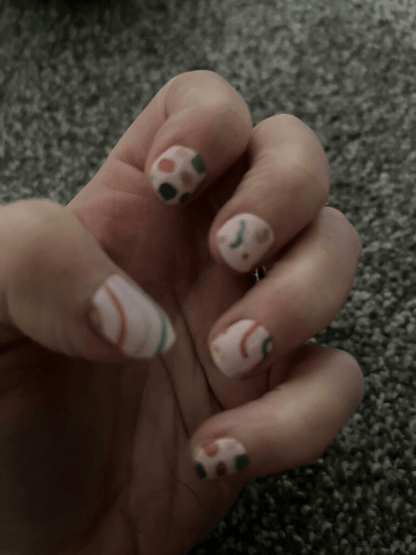 Abstract geometric nail art wraps on hand with vintage 80s Memphis design multicolour pattern