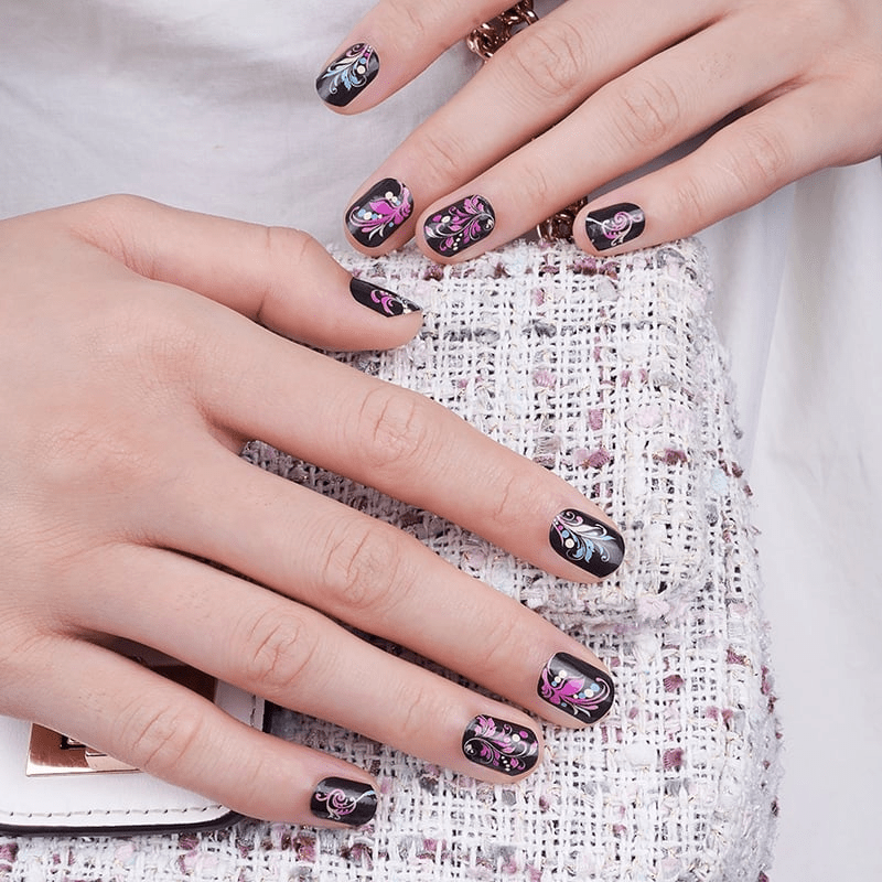 Black glossy nail wraps with pink and silver feather-like floral swirl accents