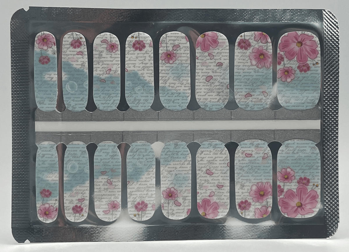 Pink floral script nail wraps with blue accents and vintage text pattern on clear backing