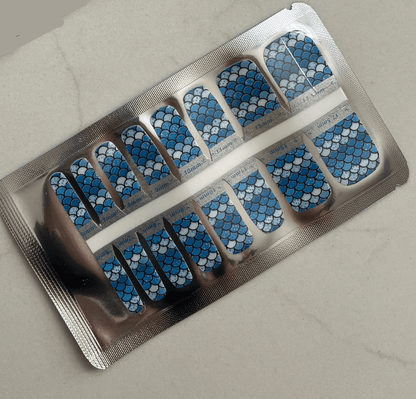 Blue mermaid scale pattern pedicure nail wraps in silver foil packaging