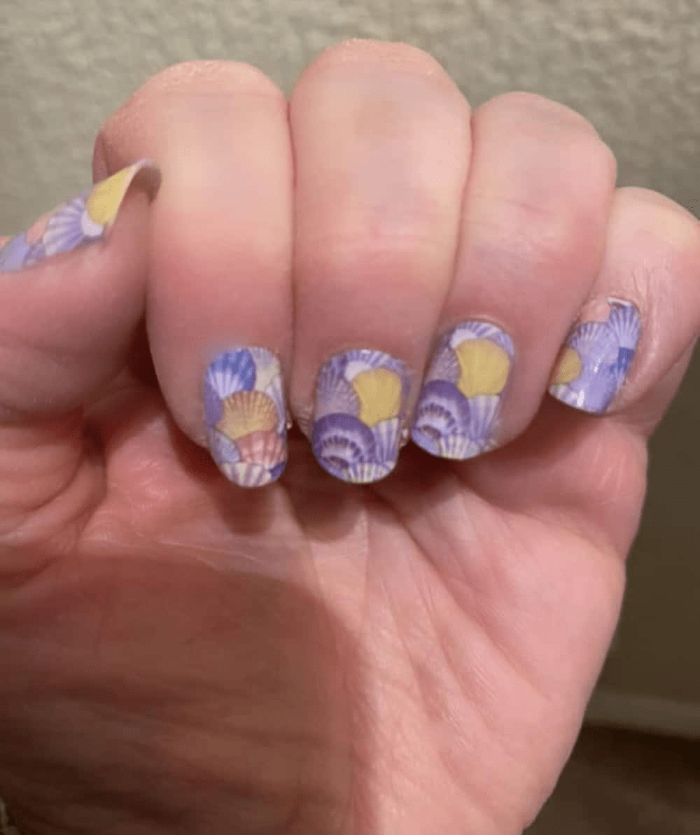 Purple watercolour seashell nail wraps with yellow details on hand manicure