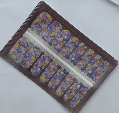 Seashell watercolour nail wraps with pastel purple and yellow ocean design in packaging