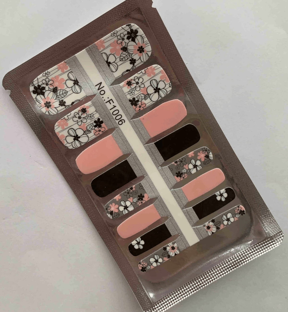 Non-UV pedicure nail wraps featuring black, pink and white floral designs in packaging