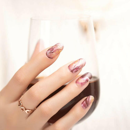 Almond-shaped nail wraps with pink, mauve and gold marbled sedimentary rock design