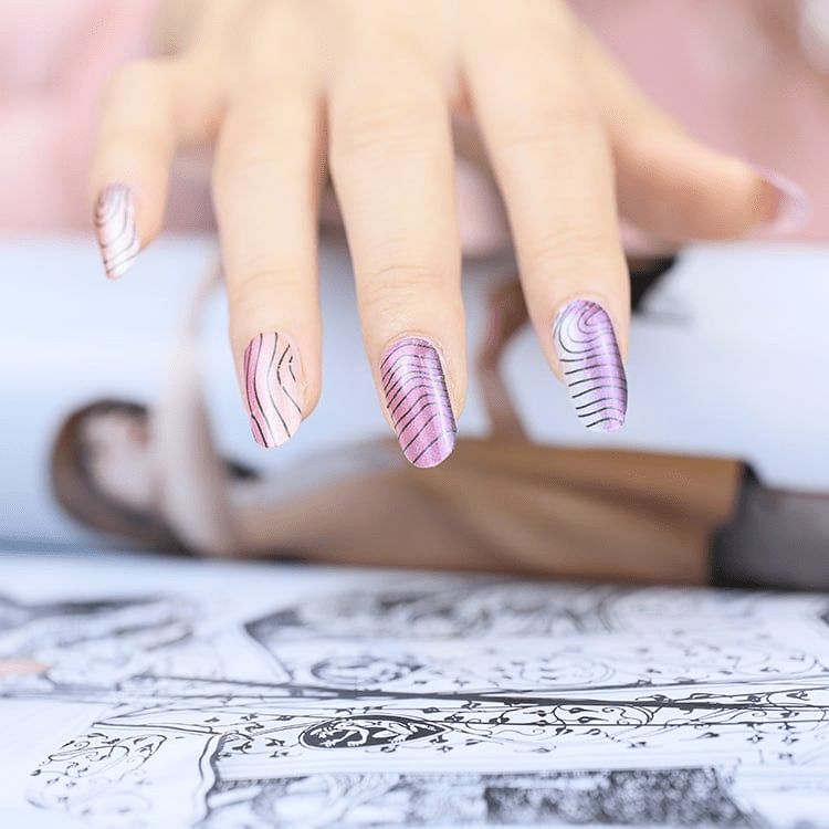 Pink and white abstract striped nail wraps on hand creating curved wave pattern manicure