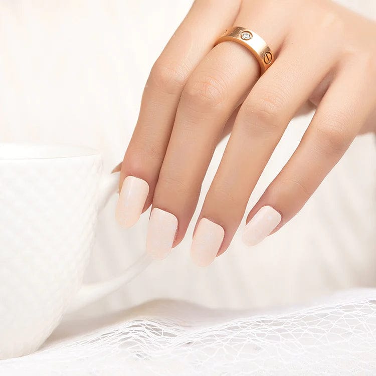 Nude pink nail wraps with delicate white lace pattern on manicured hand