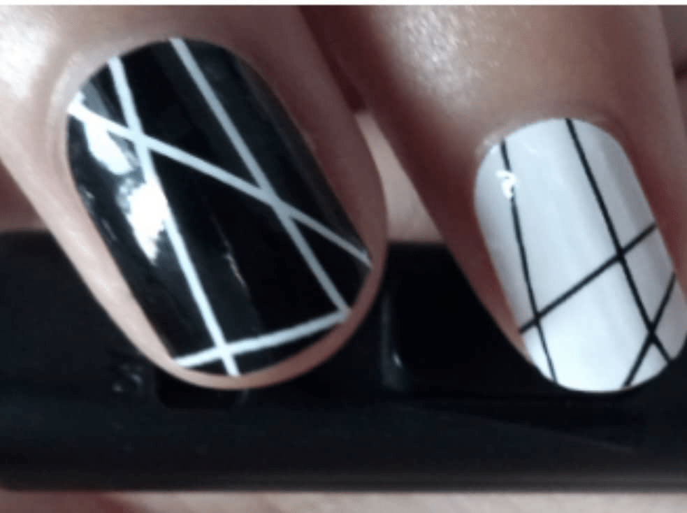 Monochrome geometric nail wraps on hand showing black and white crosshatch design