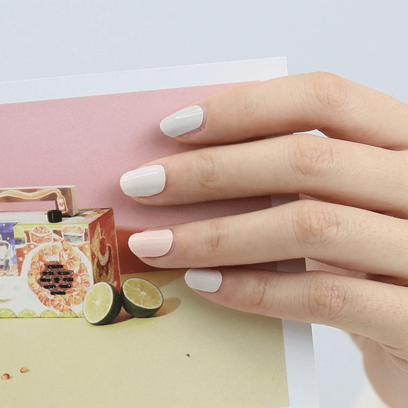 Clean white non-UV nail wraps on hand creating minimalist manicure look