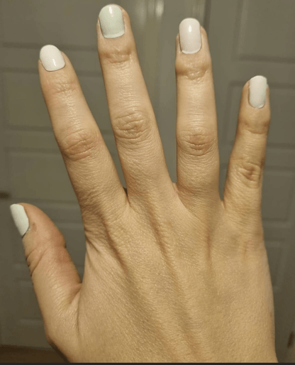 Hand displaying soft pastel nail wraps in sage green and dusty pink colours