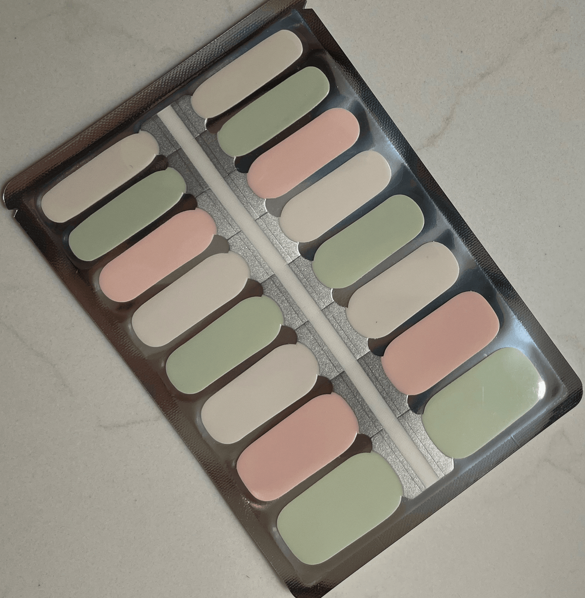 Non-UV nail wraps sheet showing sage green and dusty pink pastel colours