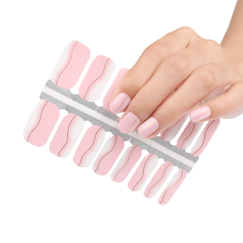 Hand applying pink nail wraps with yellow stripes from adhesive sheet