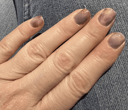 Smoky grey translucent nail wraps on hand showing minimalist marble nail art