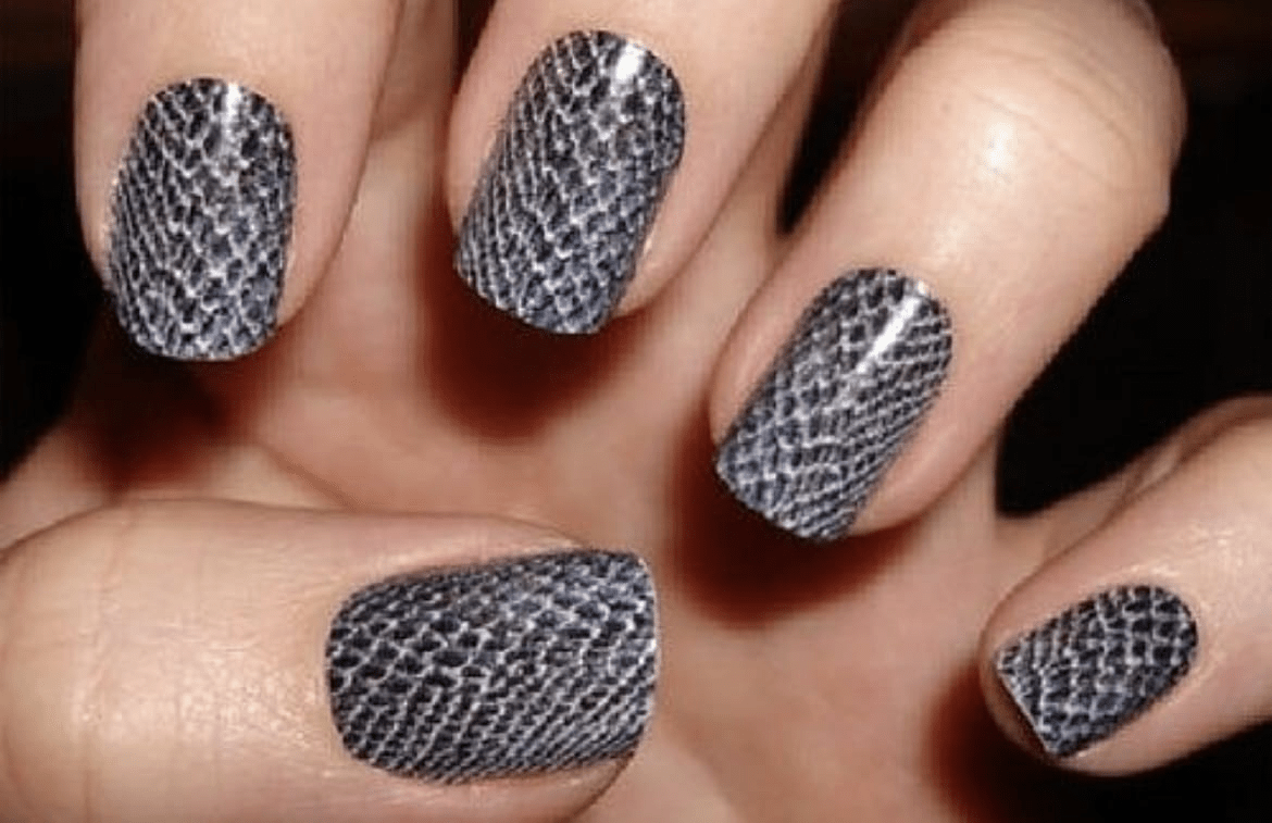 Grey snakeskin nail wraps on hand showing textured animal print manicure