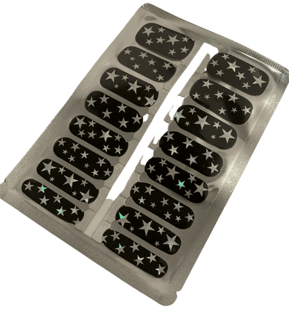 Sheet of black nail wraps with silver star pattern showing adhesive backing strips
