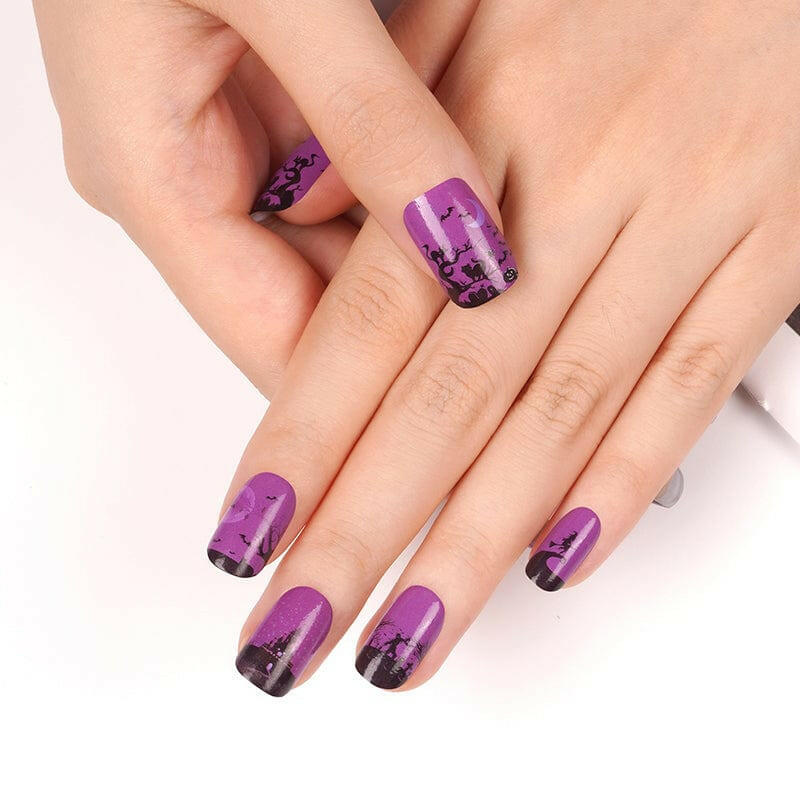 Purple Halloween nail art on hands showing gothic witch and bat silhouettes manicure design