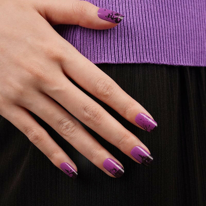 Purple nail wraps with Halloween gothic silhouettes on hand showing spooky witch and bat design