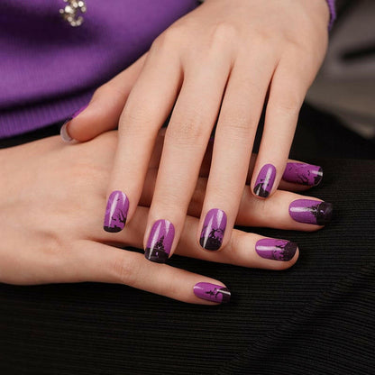 Purple Halloween nail wraps on hands featuring gothic witch silhouettes and bat designs manicure