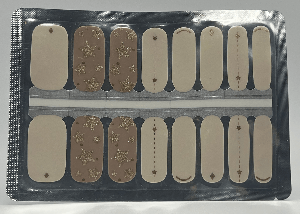 Nail wrap sheet featuring white and champagne designs with gold glitter star patterns