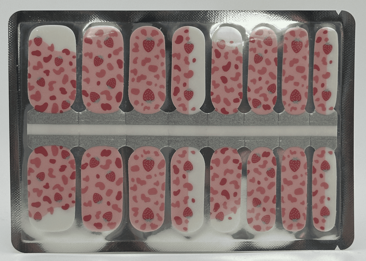 Pink leopard print nail wraps with red strawberries on a cream base