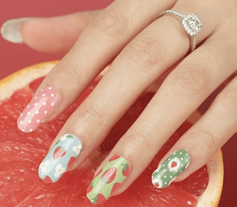 Nail wraps in pink, blue and green with polka dots, florals and strawberry prints