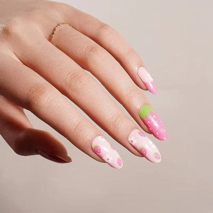 Pink strawberry nail wraps on hand showing sweet fruit patterns with green accents