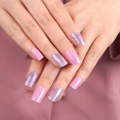 Pink holographic nail wraps on hands featuring glitter and solid pink manicure design