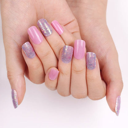 Hands showing pink glitter nail art with holographic sparkles and solid pink nails
