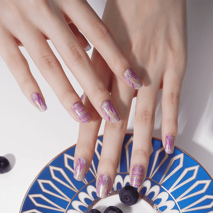 Pastel pink striped nail wraps on hands against blue decorative plate