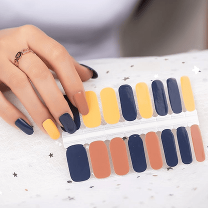 Hand applying navy blue and terracotta nail wraps from sheet