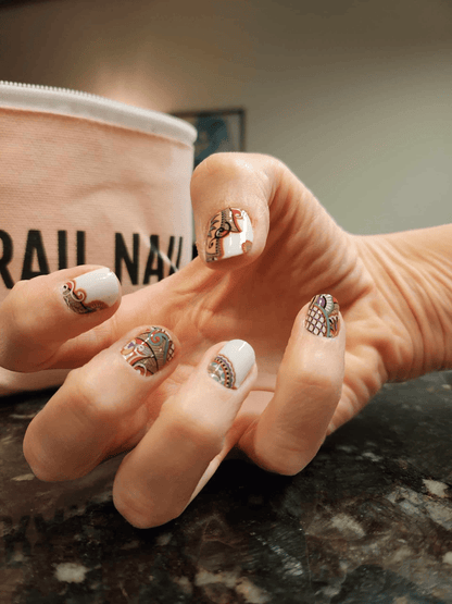 Hand wearing multicolour paisley nail wraps with intricate bohemian swirl designs on fingernails